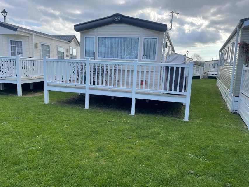 a white bench sitting on a lawn in front of a house at Island Butterfly haven in Sandown