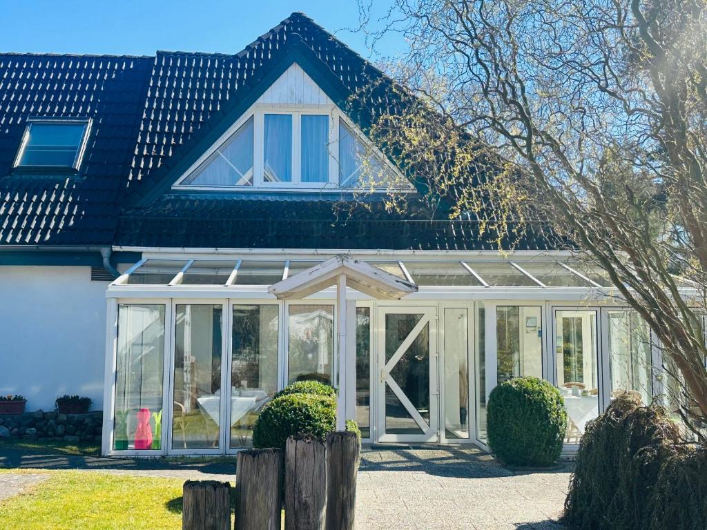 a house with a conservatory with glass at Pension Störtebeker in Prerow
