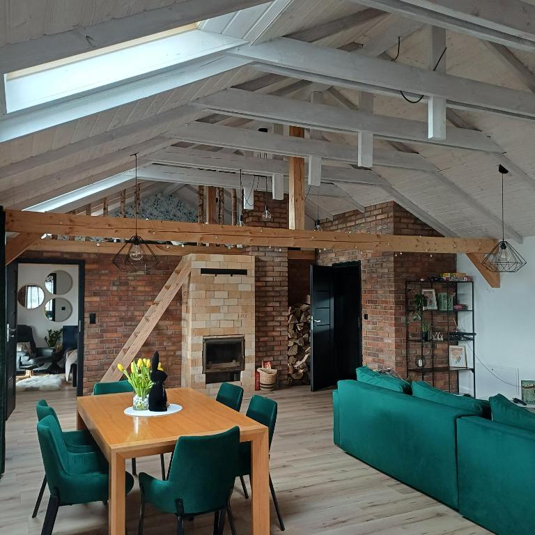 a living room with a wooden table and green chairs at Zacisze Częstkowo in Częstkowo