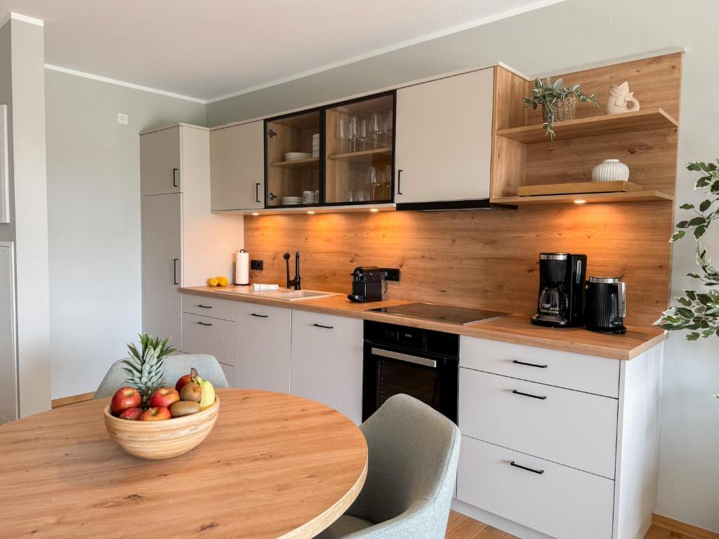 a kitchen with a table with a bowl of fruit on it at Ferienwohnung Sonnenufer am Dümmer See in Lembruch