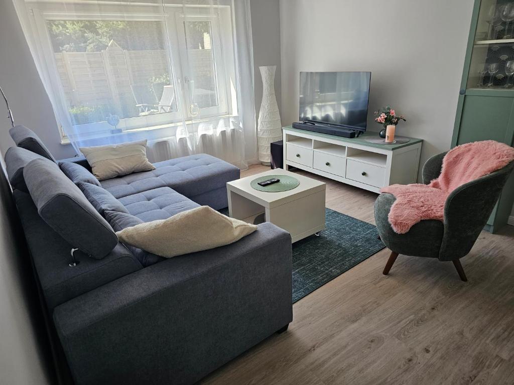 a living room with a couch and a tv at Tohuus - Fewo bei Hamburg in Hasloh