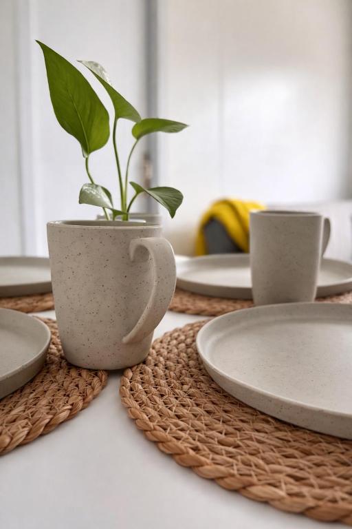 a plant in a pot on a table with plates at Casa Tetis in La Floresta