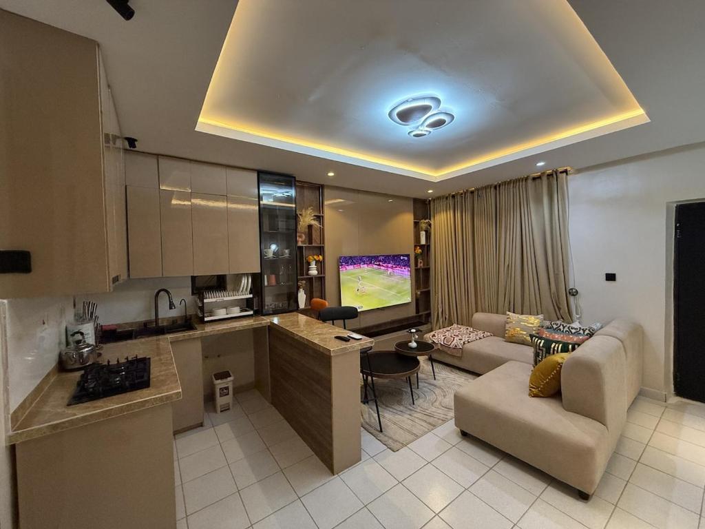a kitchen and living room with a couch and a table at Caramel Cove Lekki in Mama