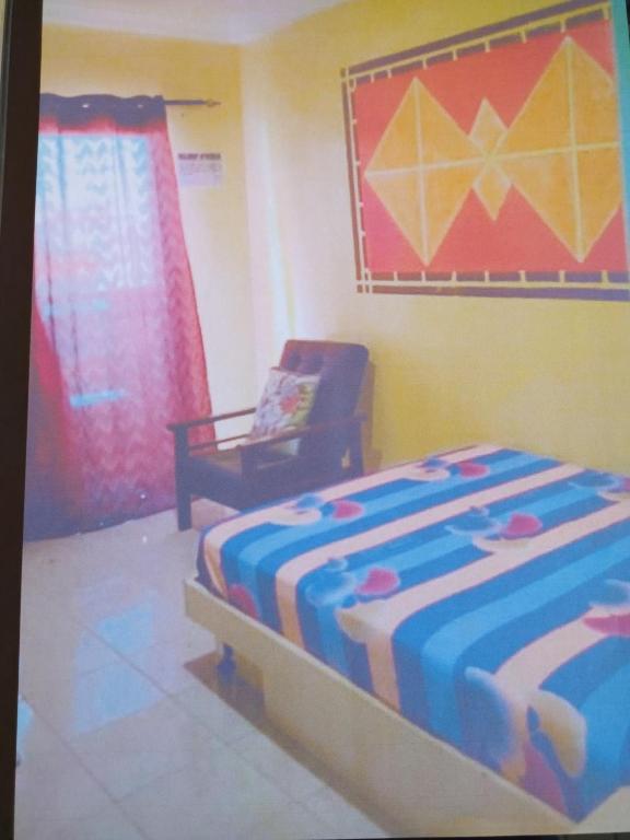 a bedroom with a bed and a chair in a room at Appartement bonita in Dakar