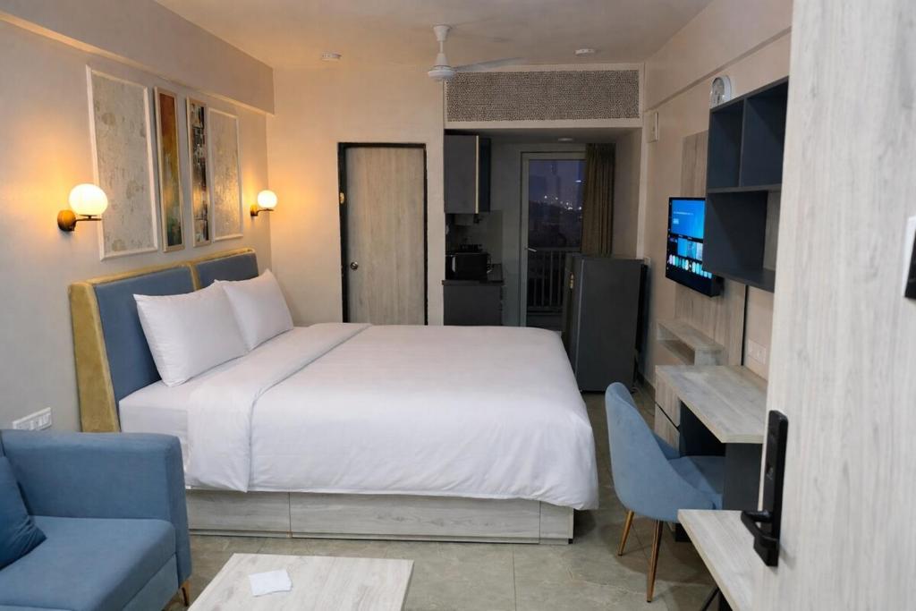a bedroom with a large white bed and a tv at Morden luxury studio in Jaipur