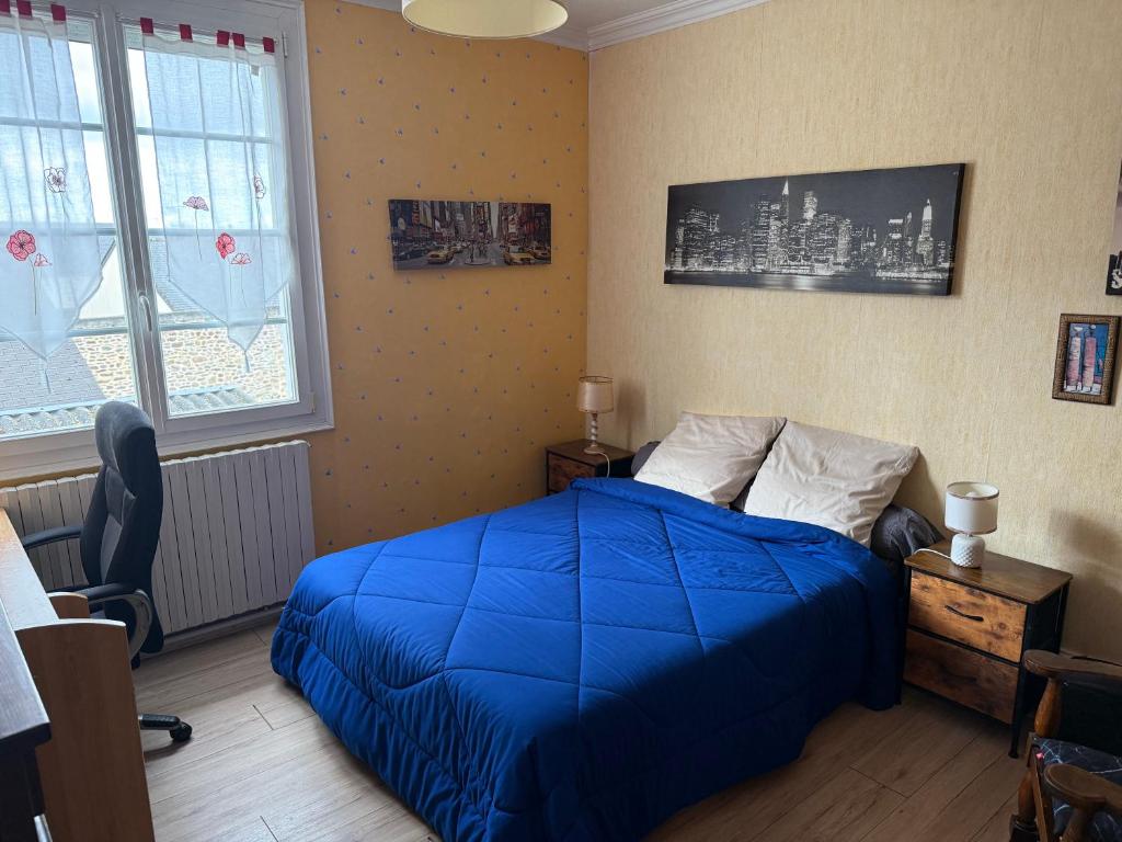 a bedroom with a bed with a blue blanket at chambre d hotes chez josiane in Mayenne