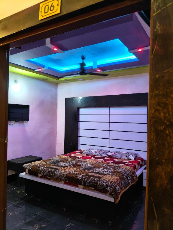 a bed in a room with a blue ceiling at The SD hotel and restaurant in Bhopal
