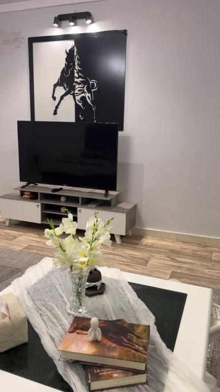 a living room with a tv and a table at لمسة فندقية راقية in Abū Marāgh
