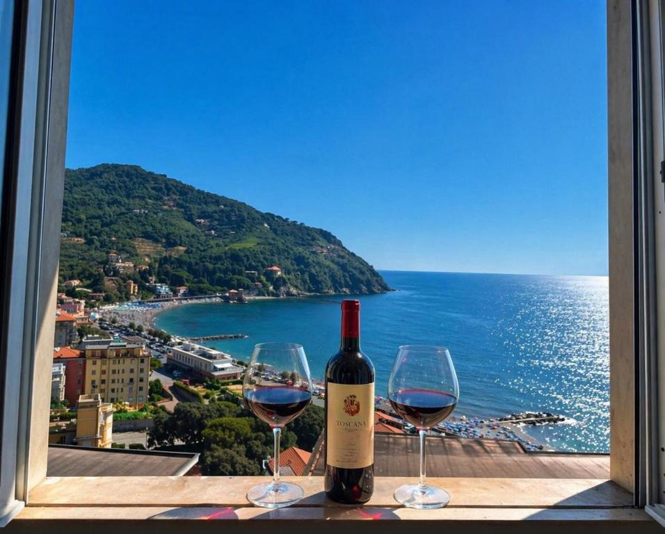 a bottle of wine and two wine glasses on a table at Ocean View Flat with WI-FI, AC and Elevator to Town in Levanto