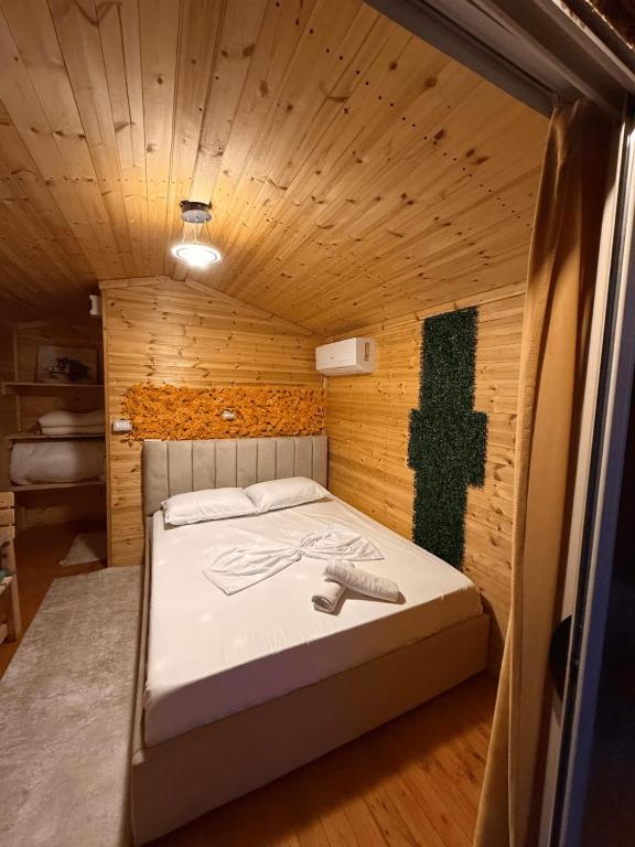 a bedroom with a bed in a wooden room at Mes Pishave in Sauk
