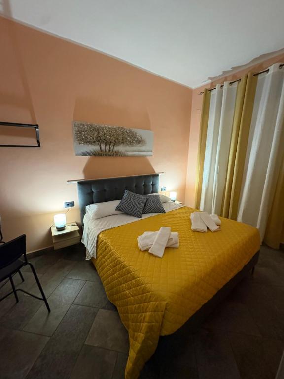 a bedroom with a yellow bed with towels on it at B&B Da Simone in Battipaglia