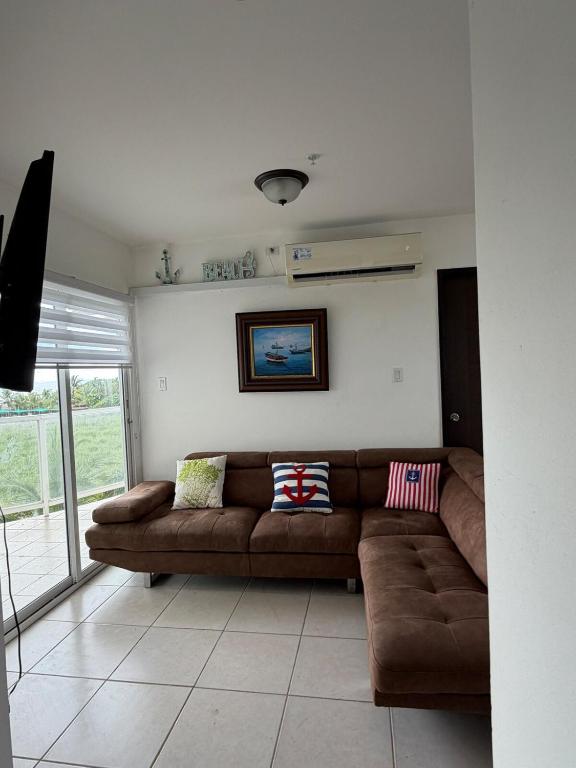 a living room with a brown couch in a room at An apartment with ocean views in Chiriquí