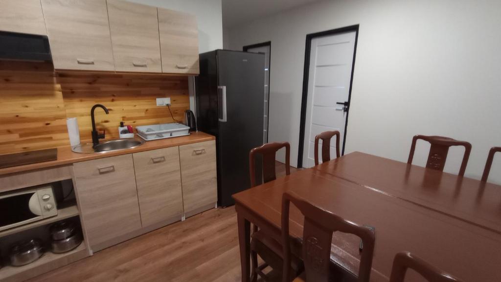a kitchen with a table and a sink and a refrigerator at Chmurka in Górno