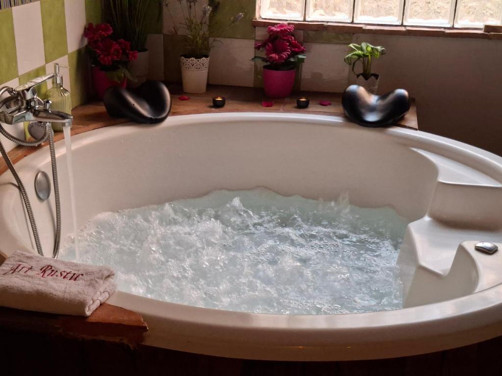 a bath tub filled with water in a bathroom at Casa Rustic Suites, JACUZI & LOVE in Xert