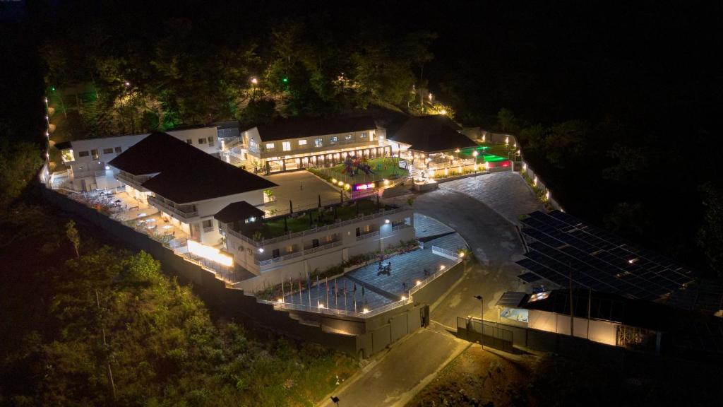 a large building with a swimming pool at night at Hillside hotel in Kenema