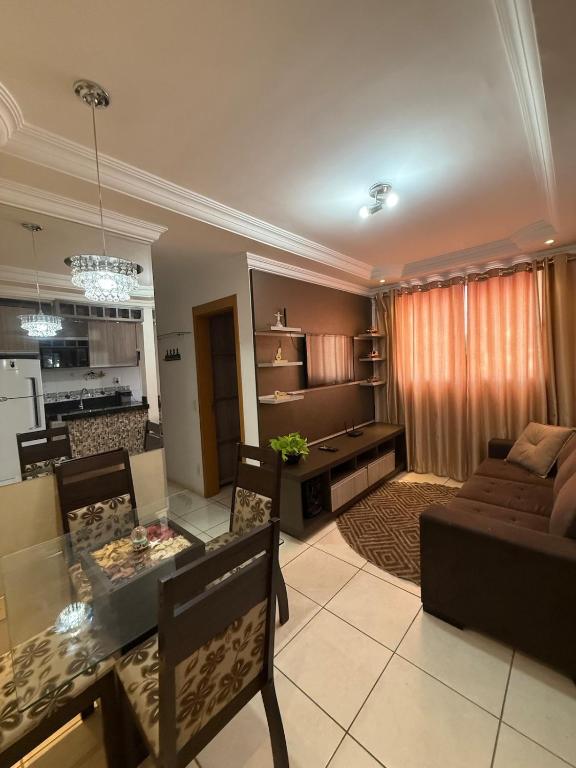 a living room with a table and a couch at Apartamento próximo Aeroporto Cuiabá in Várzea Grande