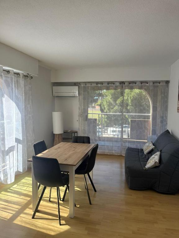 a living room with a table and a couch at Studio Hyeres sur le port in Hyères