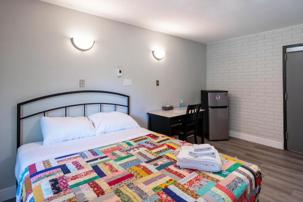 a bedroom with a bed with a quilt on it at Nekinan Lodge in Smoky Lake
