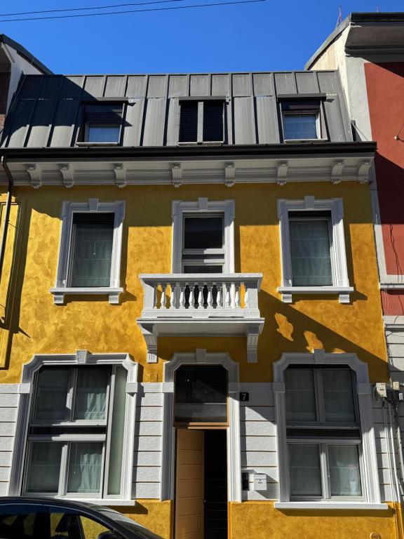 a yellow building with a balcony on top of it at Villa Dorée in Milan