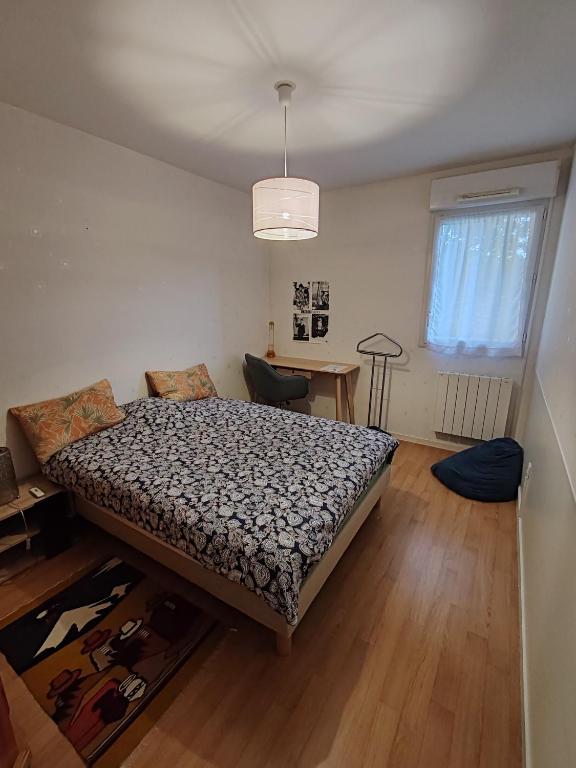 a bedroom with a bed and a table in it at Chez FLO - Appartement 1 chambre privée in Angers