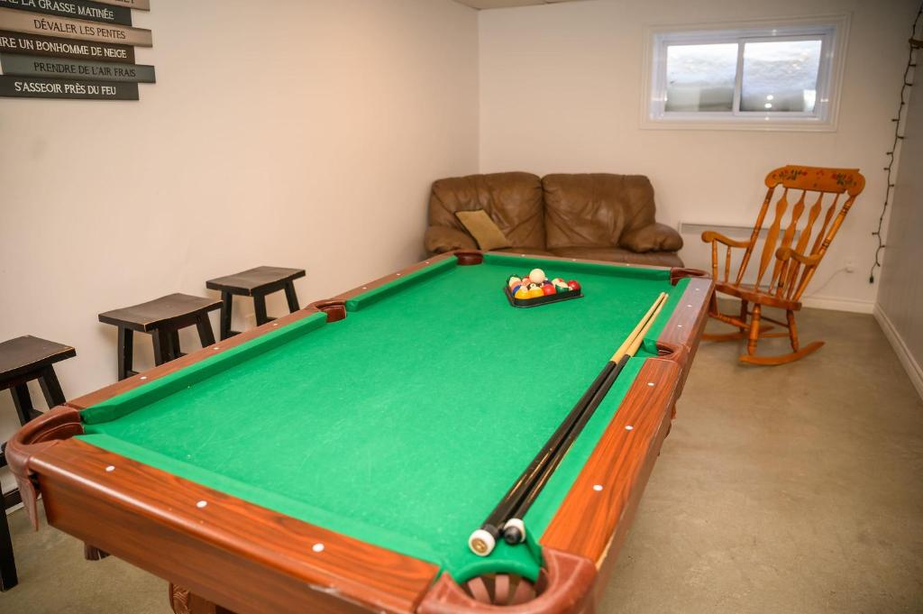 a living room with a pool table and a couch at Lower Floor - Mont-Video in Barraute
