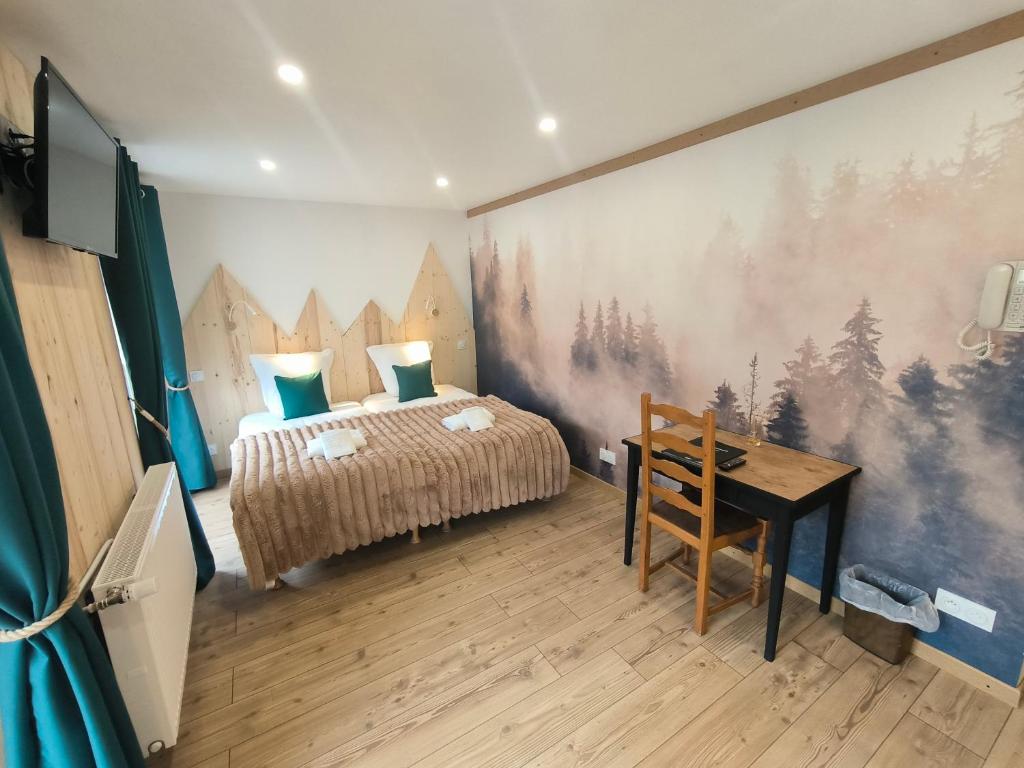 a bedroom with a bed and a desk in it at Hôtel du Centre in Valloire