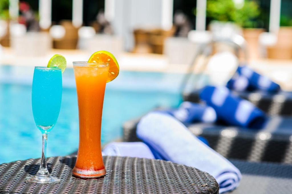 dos cócteles sentados en una mesa junto a una piscina en Hotel Selection Pattaya, en Pattaya central