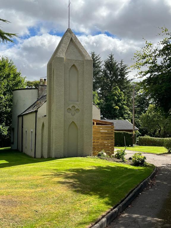 a small church with a grass yard in front of it at Craig Cottage in Banff