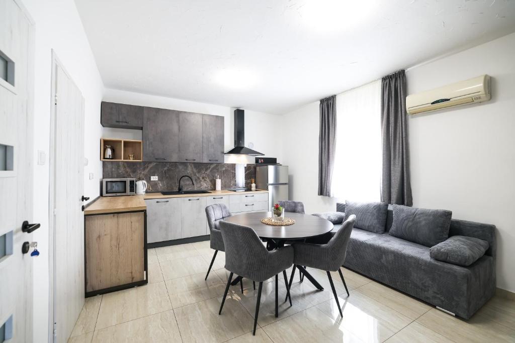 kuchnia i salon ze stołem i kanapą w obiekcie I&R Apartment w mieście Zadar