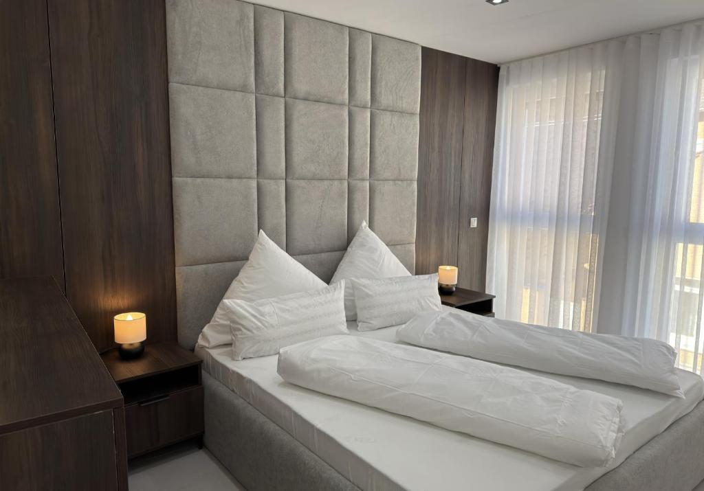 a bedroom with a large white bed with two candles at JAM Suite in Koblenz