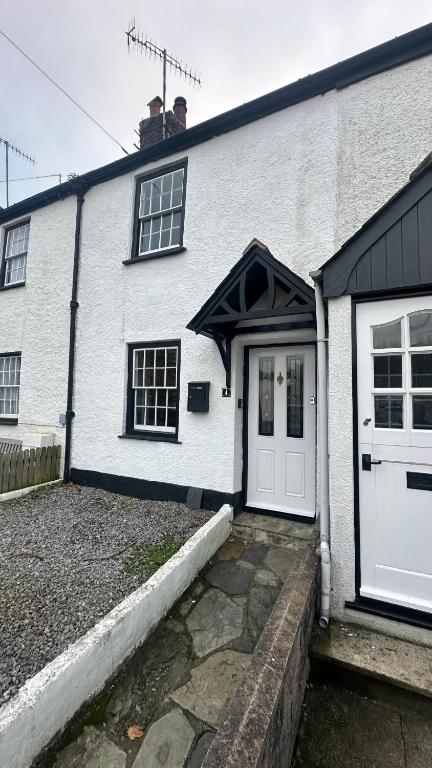 a white brick house with a white door at No 4 Devon Square in Kingsbridge