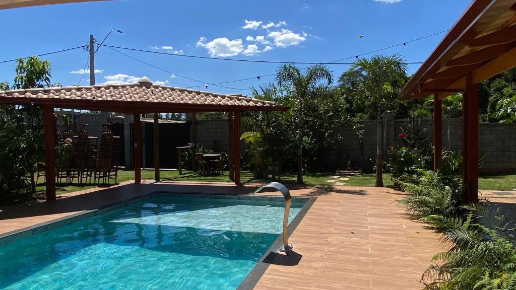 a swimming pool in a backyard with a gazebo at Recanto das Palmeiras hidro in Hidrolândia