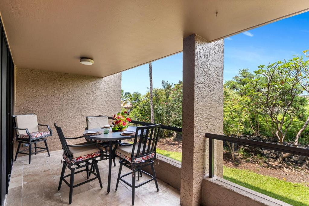 a patio with a table and chairs on a balcony at Kona Pacific C317 in Kailua-Kona