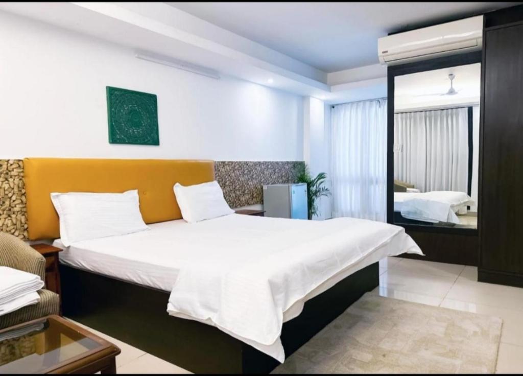 a bedroom with a large bed and a mirror at Hotel Blueberry in New Delhi