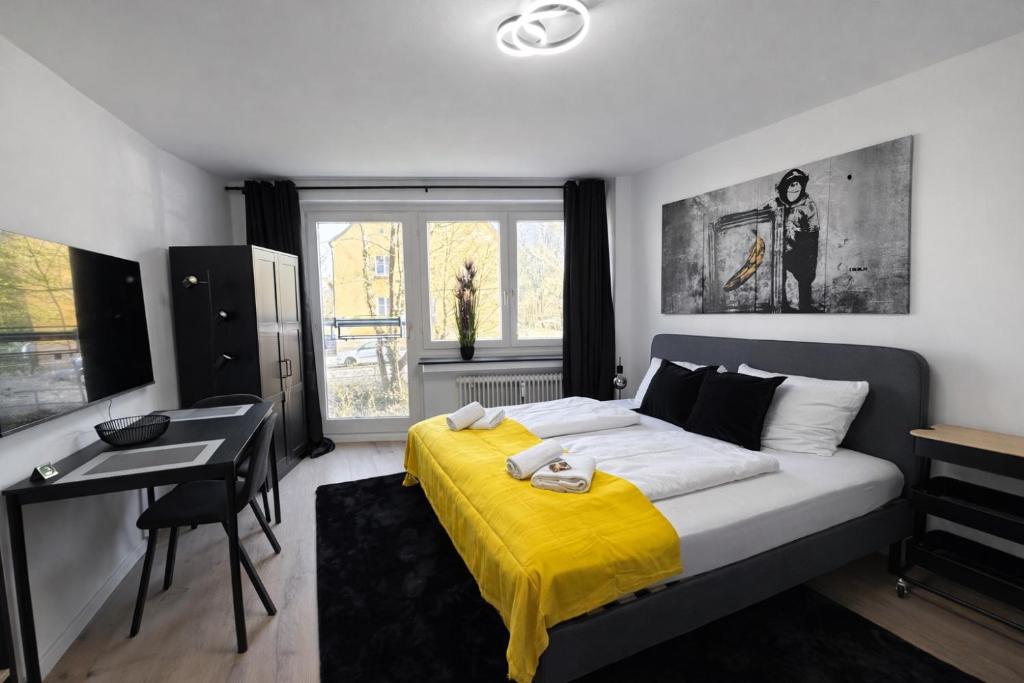 a bedroom with a bed with a yellow blanket on it at Black & Yellow Studio in Augsburg