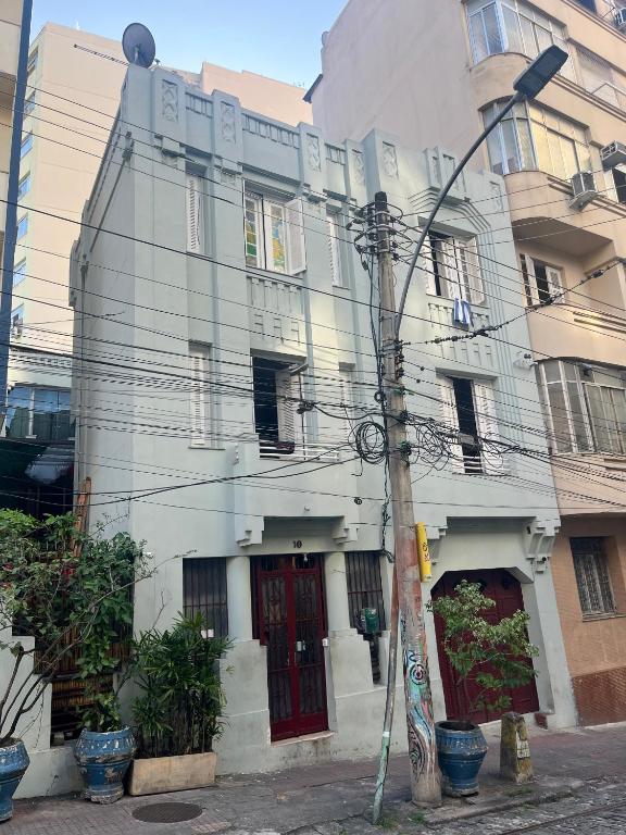 a white building with a red door on a street at Books Hostel in Rio de Janeiro