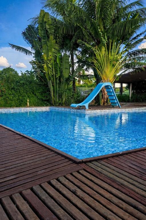 a slide in the middle of a swimming pool at Chácara Carlópolis Pr in Carlópolis