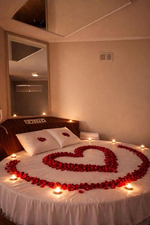a bed with a heart made out of roses at Classik Prime Motel in Araçatuba