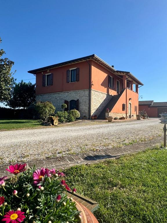a house on a road with flowers in front of it at Villa Giulia apartment Assisi in Castelnuovo