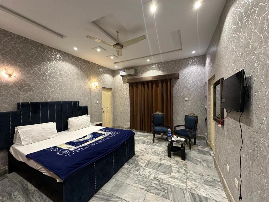 a bedroom with a bed and a flat screen tv at Hotel Sereena residence in Multan