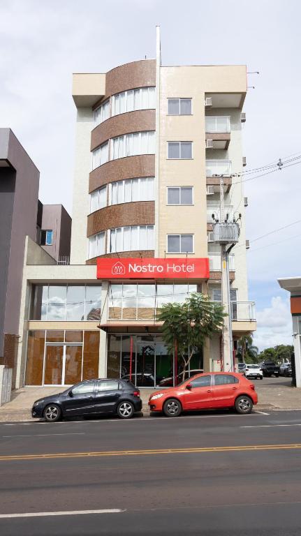 two cars parked in front of a hotel at Nostro Hotel in Pato Branco