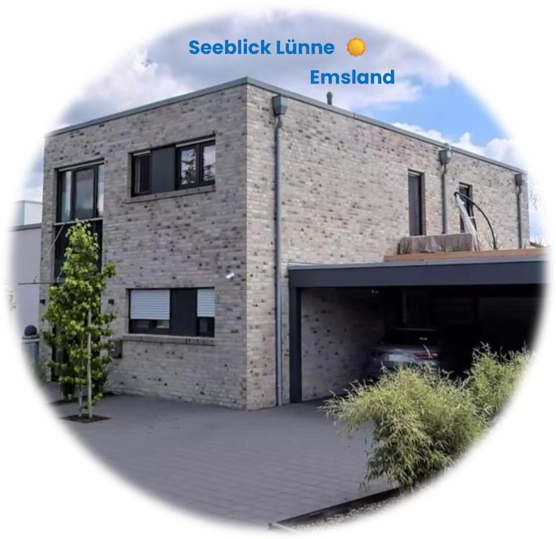 a brick building with a parking lot in front of it at Seeblick Lünne Emsland in Lünne