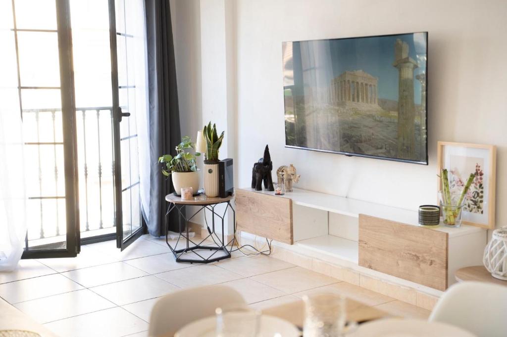 a living room with a tv on a wall at Estrella del Sur in Torremolinos
