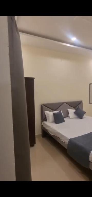 a bedroom with a bed with blue and white pillows at Badri Vishal in Varanasi
