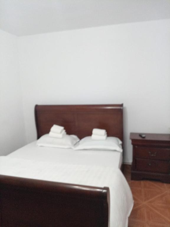 ein Schlafzimmer mit einem Bett mit weißen Laken und einem Nachttisch in der Unterkunft imocris in Fălticeni