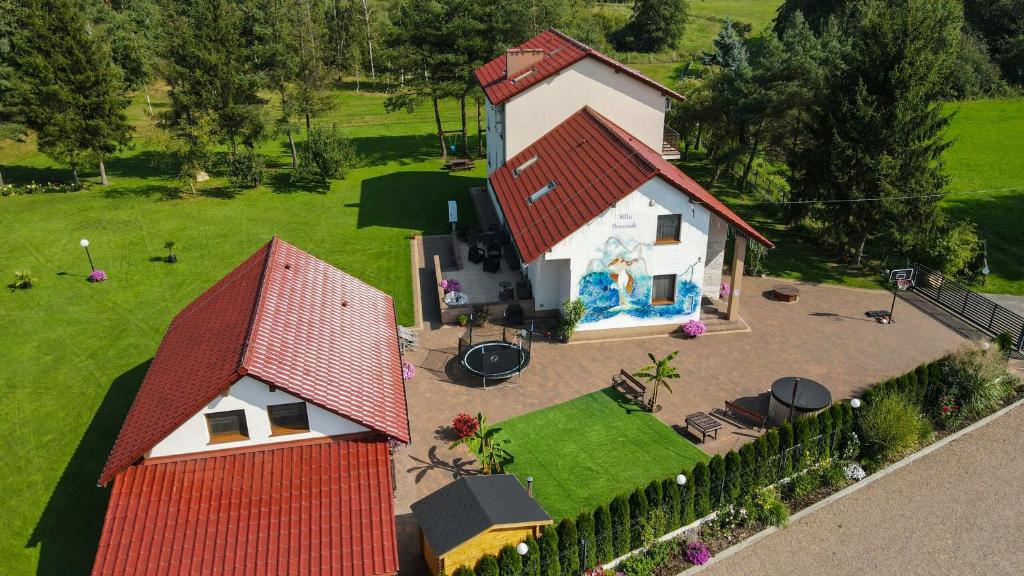 a small house with a red roof and a yard at Willa Boconek - Zator Przeciszów in Zator