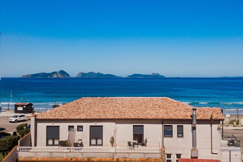 a house with a view of the beach and the ocean at Hostal Montevideo Camino De Santiago & Beachfront in Nigrán