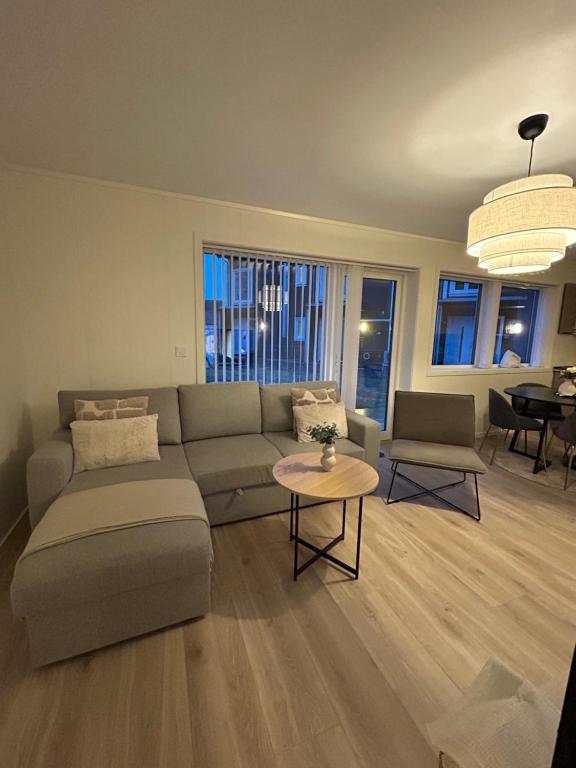 a living room with a couch and a table at GHAR-New 2 bedrooms apartment near airport and Oslo city-free parking in Klofta