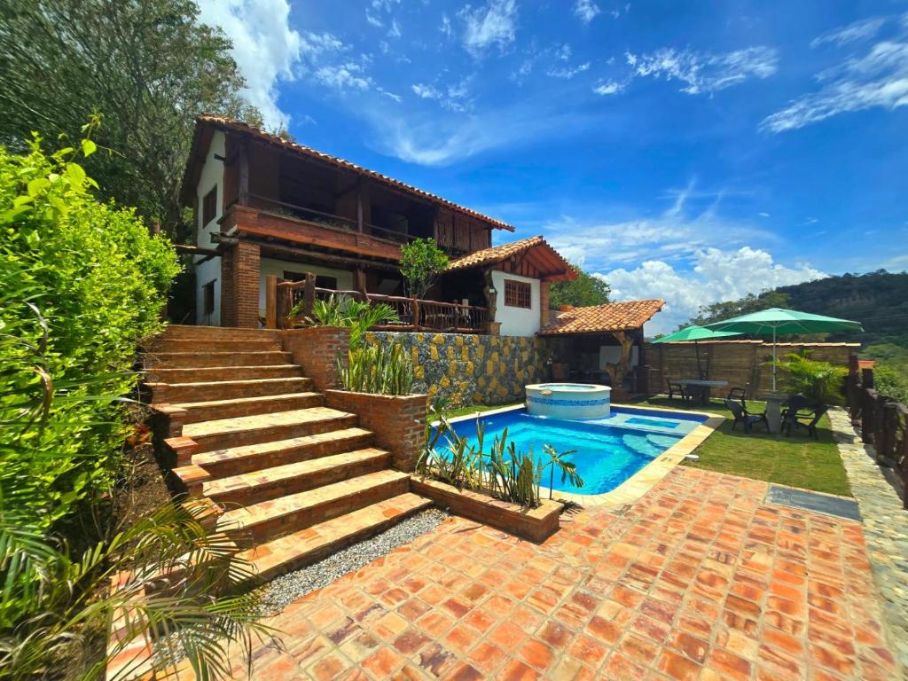 a house with a swimming pool and stairs at Cabañas el Nopal in San Gil