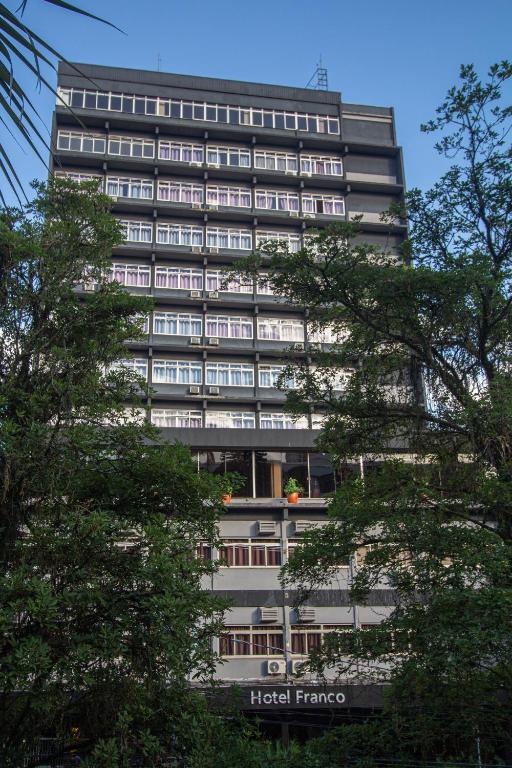 a tall building with a hotel fame sign on it at Hotel Franco Blumenau in Blumenau